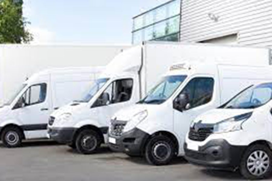 Commercial Auto Insurance Quote - Row of White Commercial Vans Outside a Warehouse Building on a Nice Day